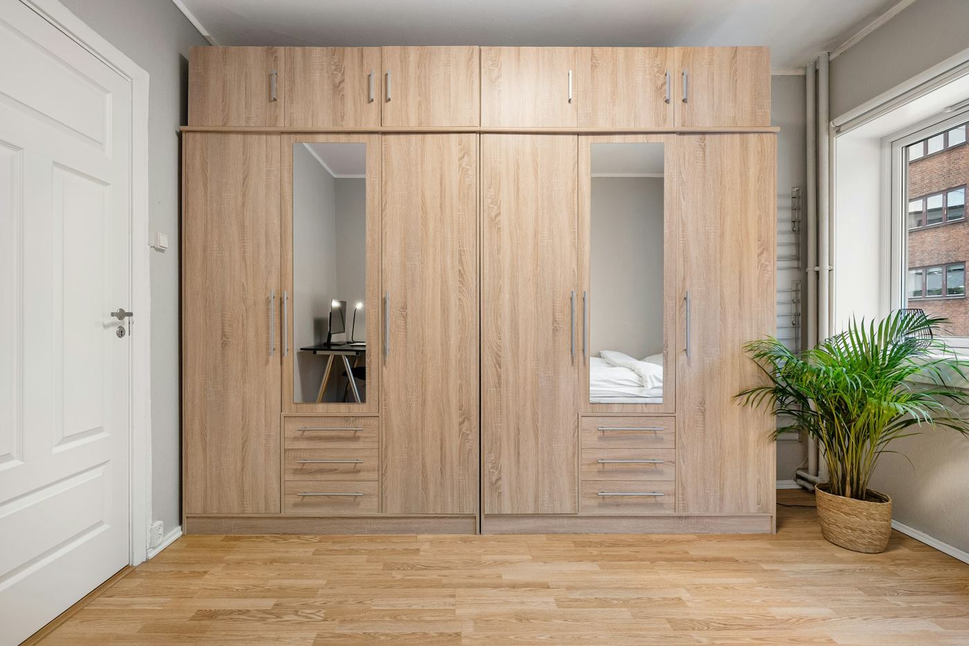 Fitted bedroom furniture scheme with matching wardrobe doors, drawer unit and bedside cabinets in a single finish