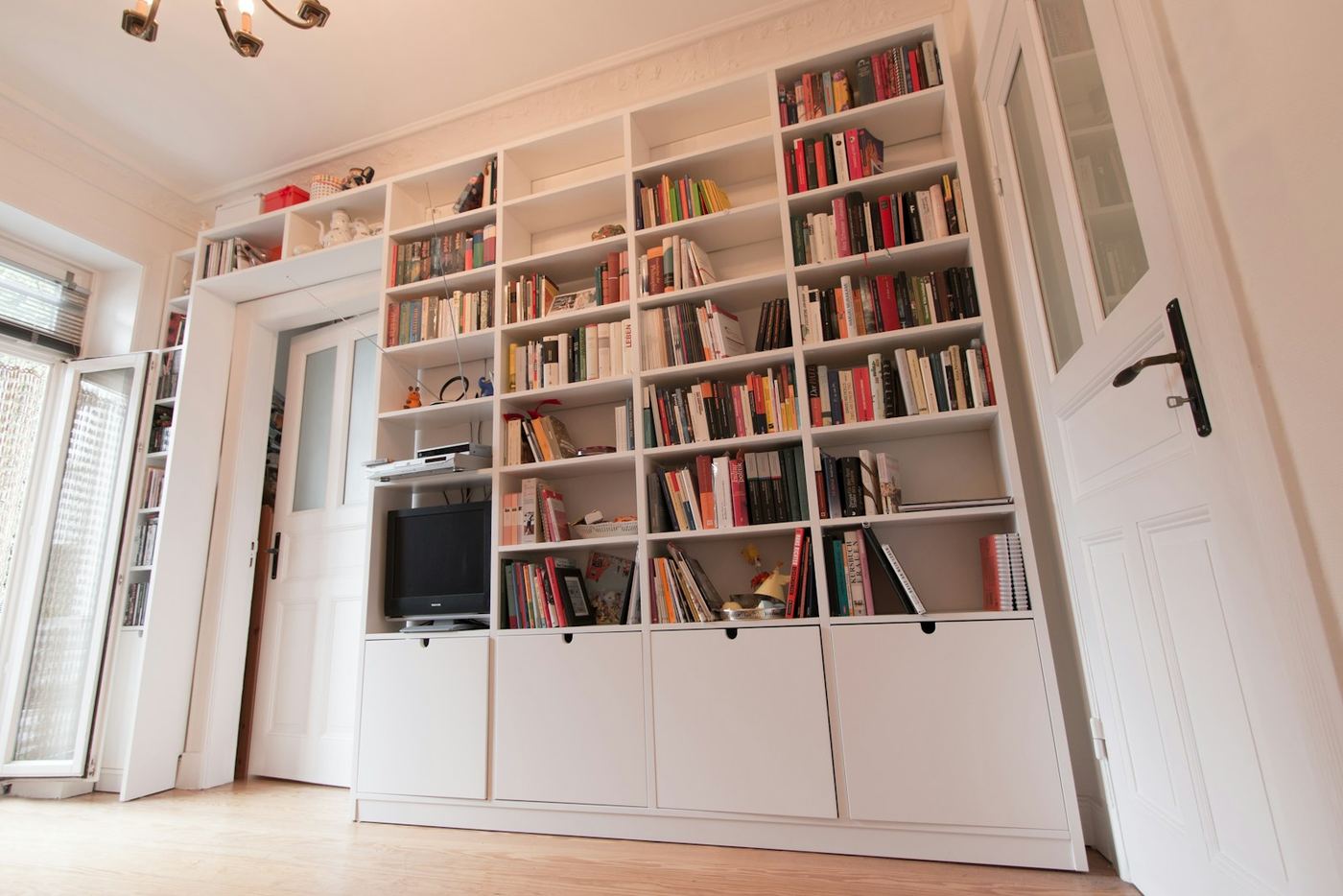 Bespoke fitted shelving and storage running floor to ceiling along a wall