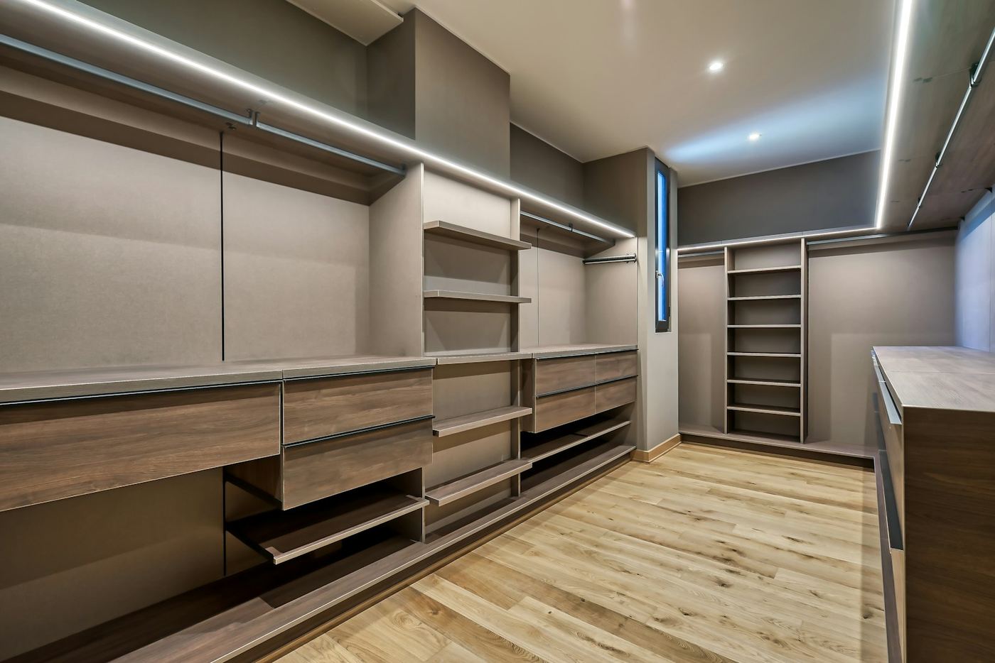 The Oakford — warm oak veneer fitted wardrobe run with open shelving and integrated lighting