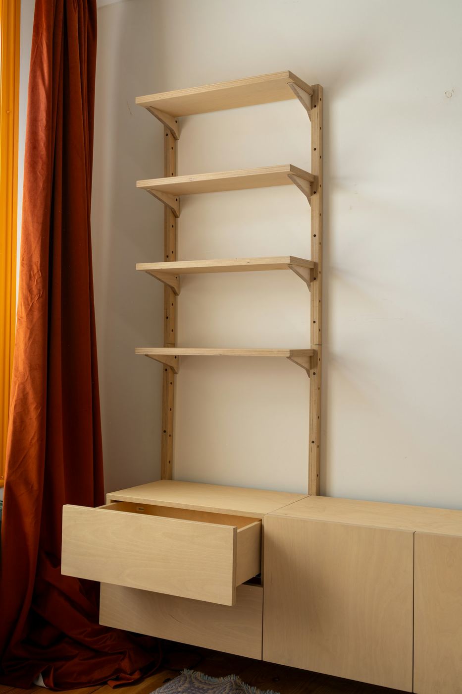 Built-in living room storage with open shelving above and closed cabinets beneath