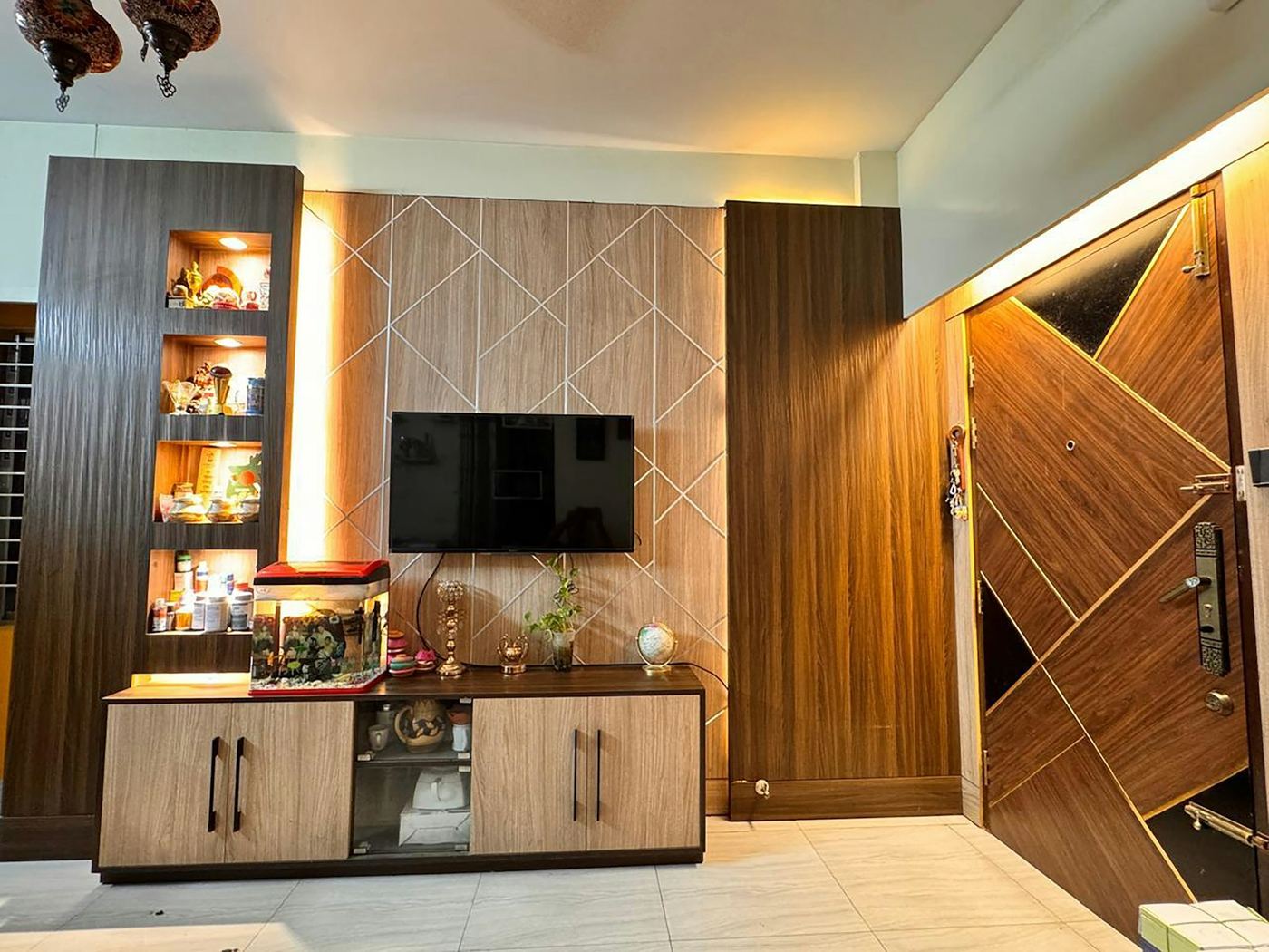 Built-in media wall with a recessed television, storage beneath and shelving running alongside
